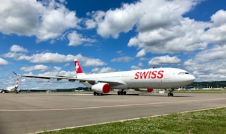 white and red passenger plane on airport during daytime