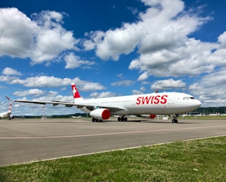 white and red passenger plane on airport during daytime