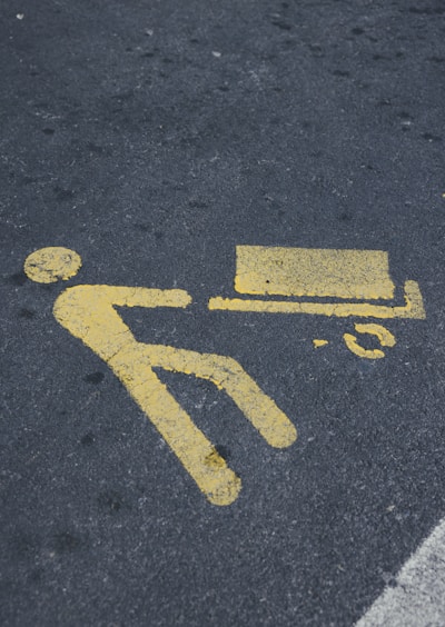 a yellow sign on the ground indicating a bench